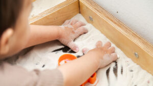 Kid playing with sand, sensory processing, occupational and psychomotor therapy in Dubai at TBC, Talking Brains Center